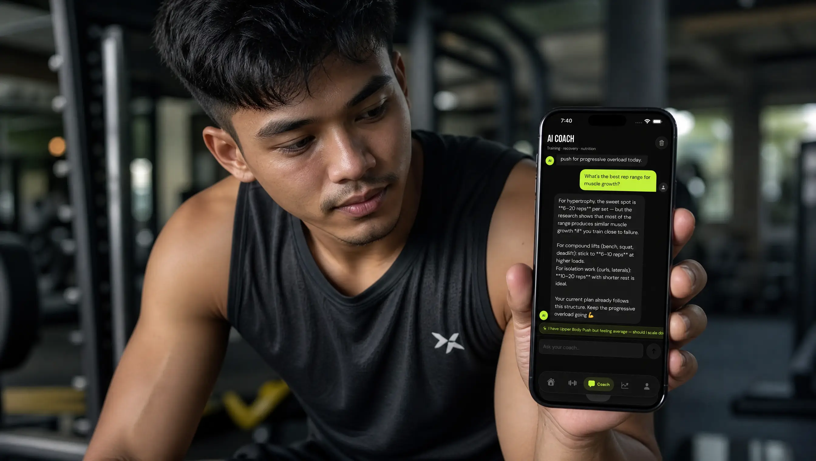 A man in a Malaysian gym using an AI coach app on his phone instead of a personal trainer